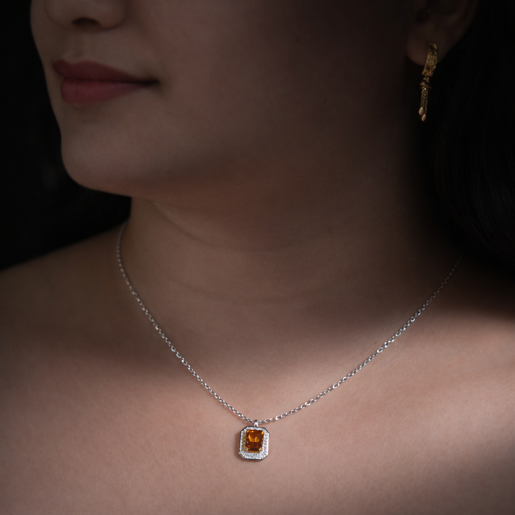 Close-up of a person wearing a silver necklace with a pendant.
