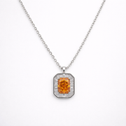 Diamond necklace with a central orange gemstone on a white background